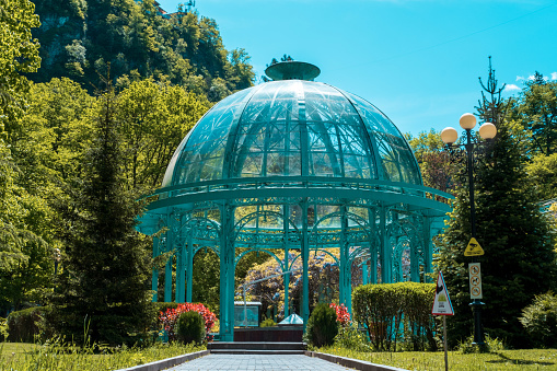 Source with healing mineral water. Beautiful pavilion with a glass dome in Borjomi Central Historical Park. Georgia.