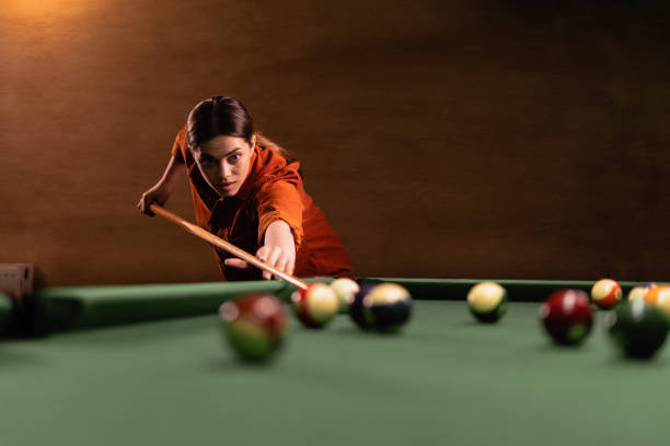 istock Woman's hand with cue pointing at billiard ball at table 1497206787