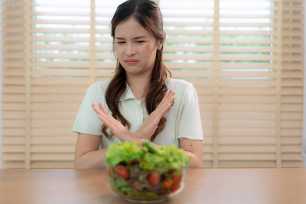 Asian women don't like eating green salads, She was bored and didn't like the smell of it. Asian women don't like eating green salads, She was bored and didn't like the smell of it. dont eat meat stock pictures, royalty-free photos & images