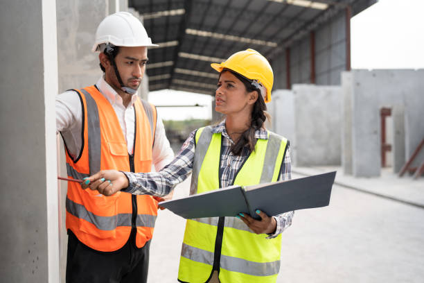 istock Working India engineer woman use document and talking with Asia engineer man at precast site work 1497209654
