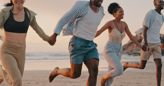 Holding hands, happy or friends running at beach at sunset on holiday vacation bonding or walking together. Smile, freedom or funny group of people relaxing on sand on ocean trip in Miami or nature