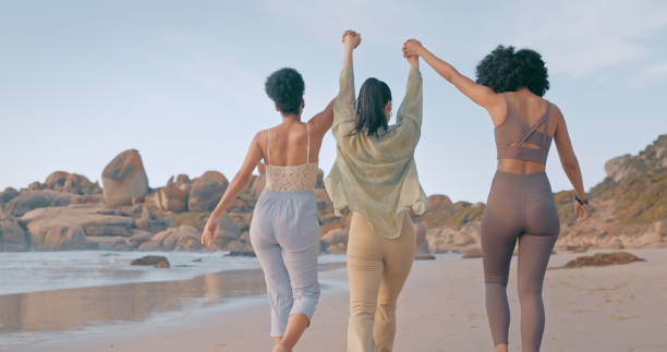 istock Holding hands, friends or walking at a beach for holiday vacation while bonding or laughing together. Happy people with women group relaxing at seashore on an ocean trip in Miami 1497209681