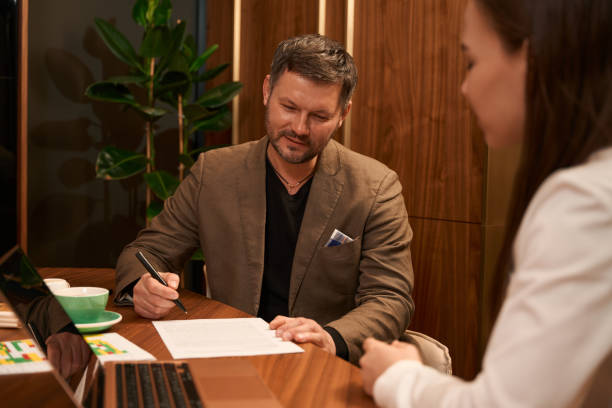 istock Adult man signing document in the office 1497211146