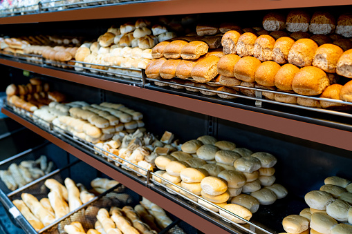 Variety of salty and sweet breads on retail display at a supermarket's bakery - Food and drinks industry concepts