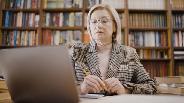 istock Serious mature woman looking at her laptop screen, working from home, freelancer 1497213306