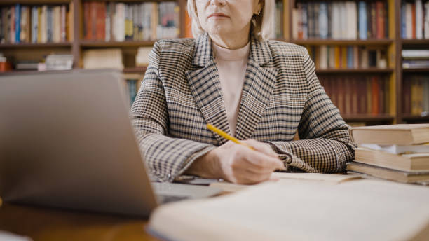 istock Confident woman in her 50s working on a laptop, making notes, writer by occupation 1497213307