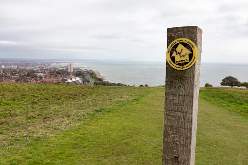 Eastbourne, UK -May 02, 2023: Wooden signpost on chalk cliffs near Beachy Head, Eastbourne, East Sussex, England