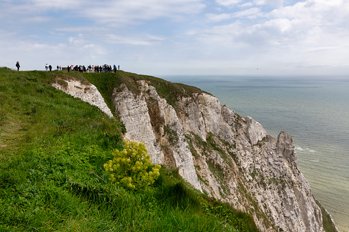 Eastbourne, England - May 2, 2023: Walkers on the chalk headlands in East Sussex, England called Beachy Head. Lies very close to Eastbourne and immediately east of the seven sisters county park. It is the highest chalk cliffs in Britain, rising to 162m in places.