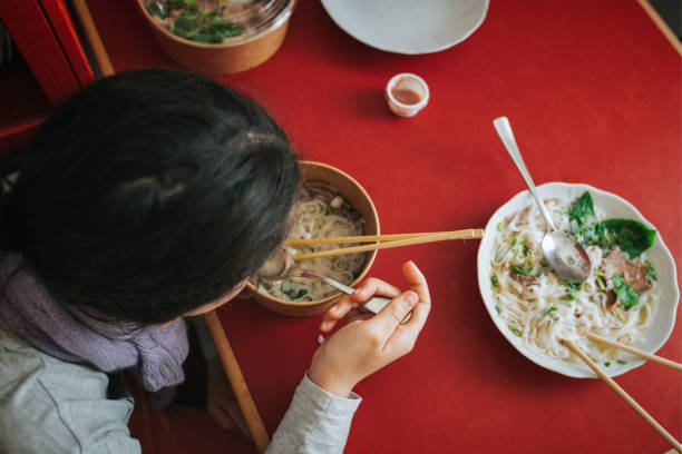 overhead view on girl eating pho soup from delivery service