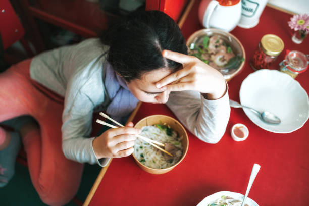 overhead view on girl eating pho soup from delivery service