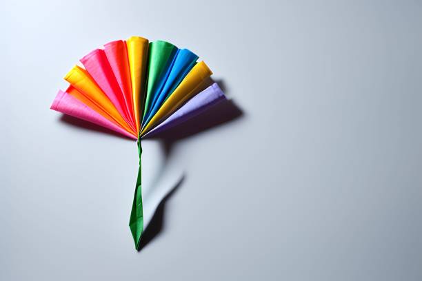istock Origami paper flower and leaves arranged on a white table top illuminated with a bright, soft light 1497217685