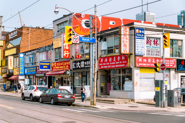 Toronto, Canada - June 4, 2023: Chinatown. Street-side commercial buildings with multiple signs. Incidental people are in the scene.