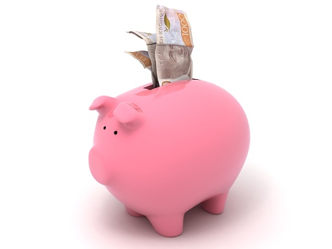 Pink Piggy bank money concept on dark blue background, stuffed with Australian cash.