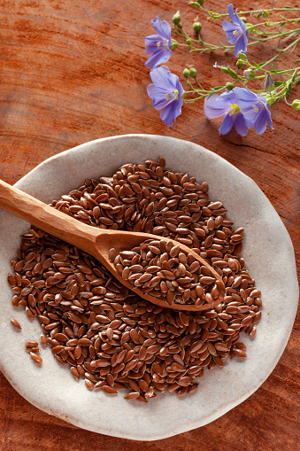 Flax seeds and flax flowers on the table