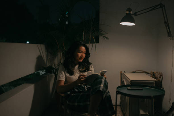 istock Asian woman enjoying reading a book at night. 1497230647