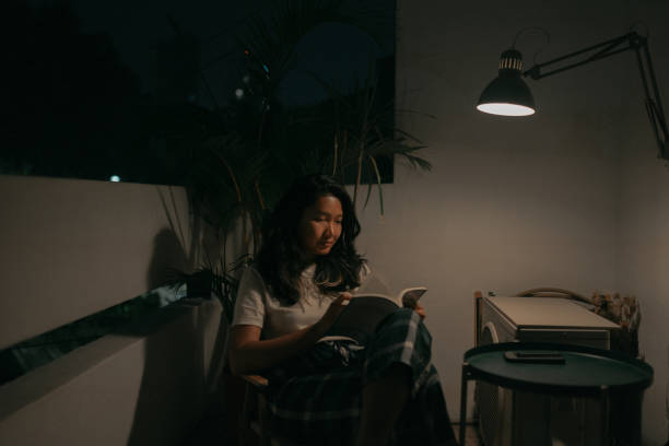 istock Asian woman enjoying reading a book at night. 1497230649