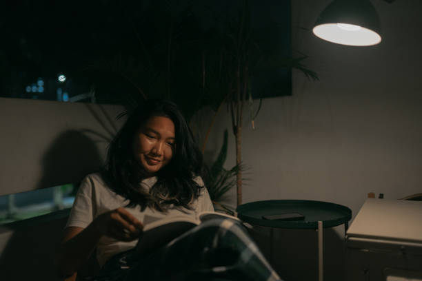 istock Happy asian man reading a book at balcony. 1497230662