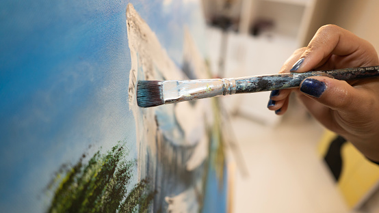 Row of artist paintbrushes closeup on artistic canvas.