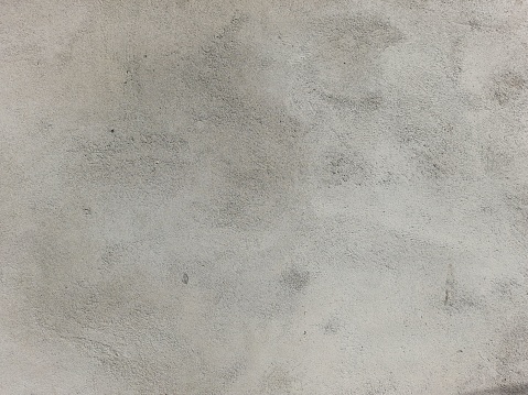 A close-up shot of a white cement surface featuring a corner with black marks on it