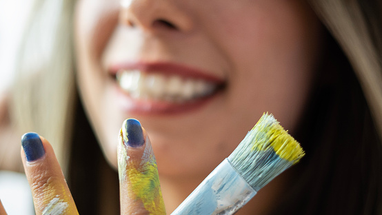 Smiling female artist holding art brush