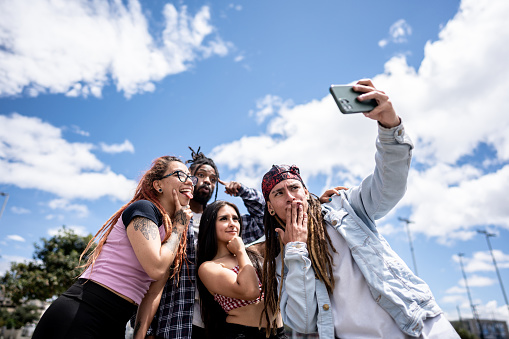 Friends taking a selfie using a mobile phone outdoors