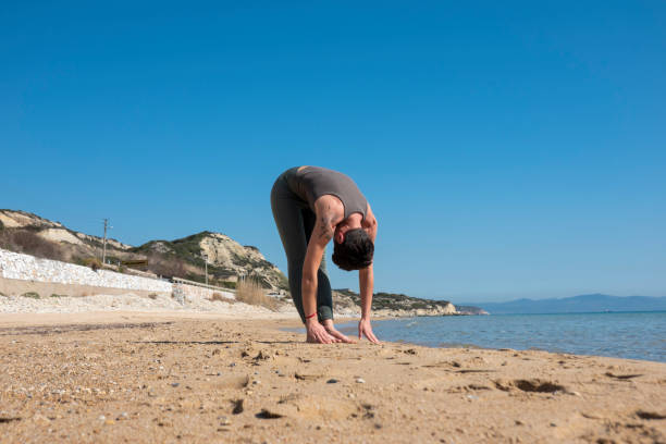 istock Attractive middle-aged woman practicing yoga on a beautiful beach 1497240936