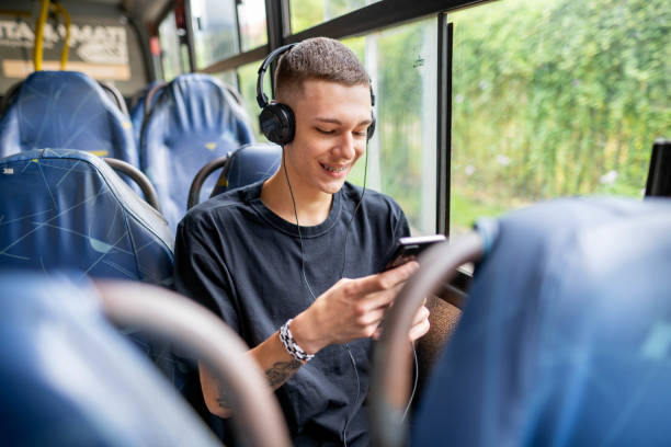 istock Smiling young man watching a streaming video on his phone on a bus 1497242854