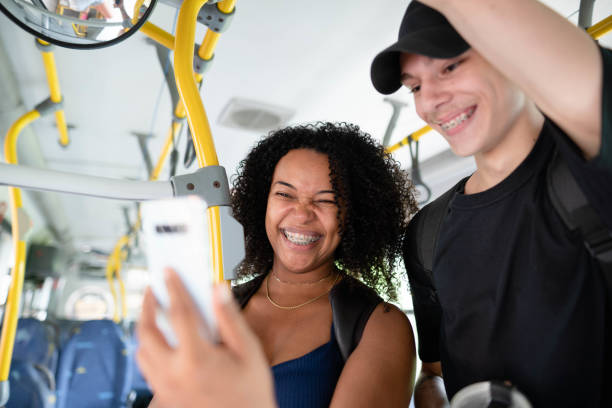 istock Laughing young friends streaming a video on a phone on a bus 1497242864