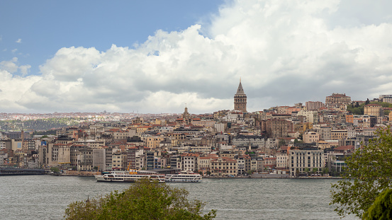 Panoramic skyline of European side of Bosphorus Strait overlooking Galata Tower with cloudy sky in a spring day, Istanbul, Turkey