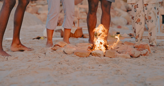 Campfire, dance or legs at beach for holiday vacation bonding or relaxing together on sand in solidarity. Friends, zoom or group of people standing or dancing at seashore on fun ocean trip in Miami