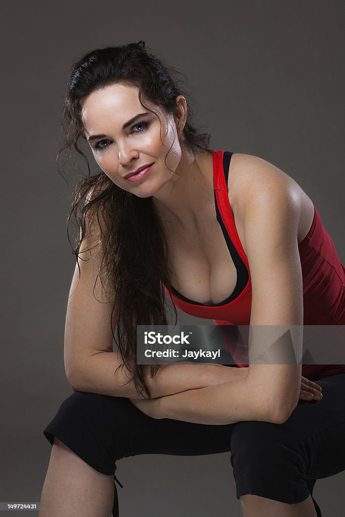 Beautiful happy sexy woman resting after exercise A young happy beauitul sexy woman having a rest after exercise Activity Stock Photo