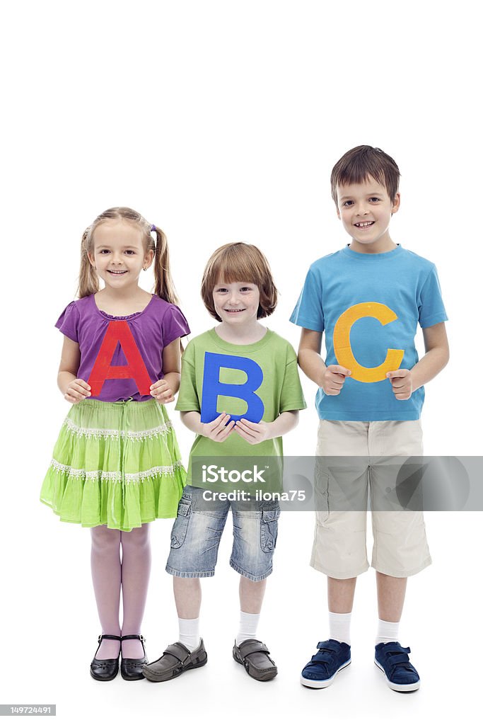 Happy school kids holding large abc letters Happy school kids holding large abc letters - learning concept, isolated Alphabet Stock Photo