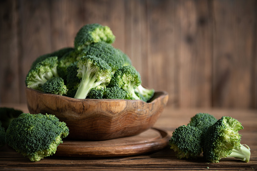 Broccoli in bowl on wooden background