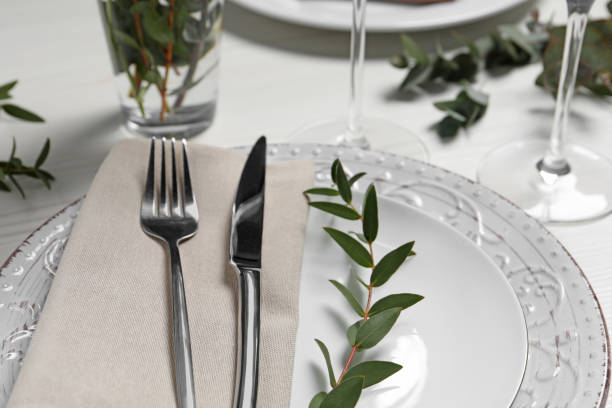istock Stylish setting with cutlery and eucalyptus leaves on white wooden table, closeup 1497249742