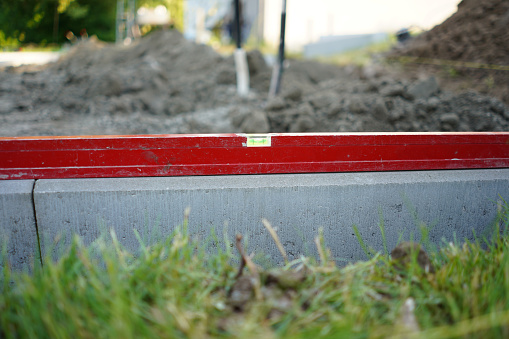Level on the concrete kerb. Leveling on the construction site. Work zone. Measurement. Red level.