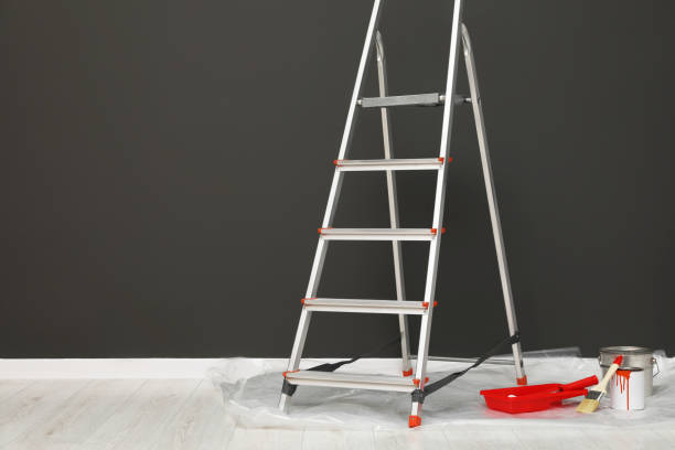 istock Metallic folding ladder and painting tools near gray wall indoors, space for text 1497251892