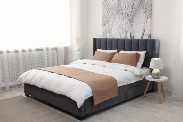 istock Comfortable bed and lamps in light spacious room. Stylish interior 1497251975