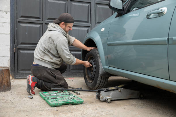 istock Auto mechanic changes the front wheel in the car. 1497254879