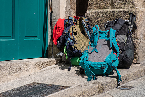 pilgrims' backpacks piled up at the door of a pilgrims' hostel on the Camino de Santiago.