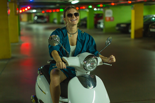 Woman in sunglasses on scooter