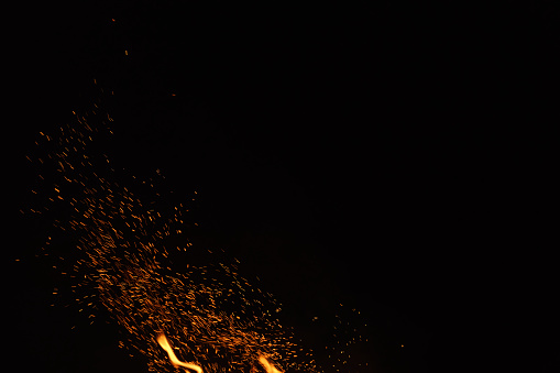 hot spark from campfire over night sky, shallow focus