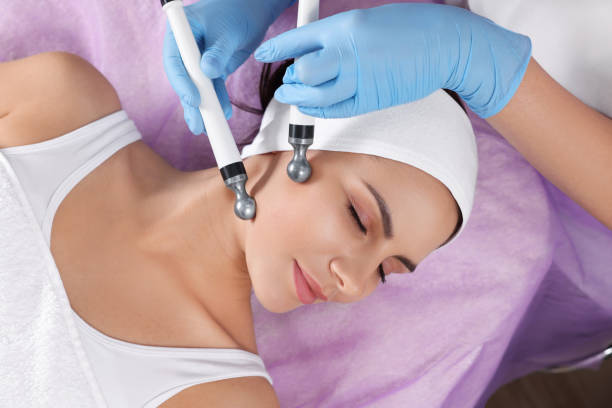 istock Young woman undergoing cosmetic procedure in beauty salon, top view. Microcurrent therapy 1497257306