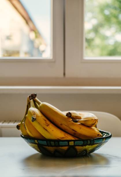 istock a bunch of bananas on a table in front of a window 1497257943