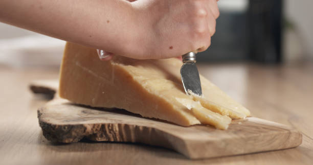 istock female hand cutting hard parmesan cheese 1497258192