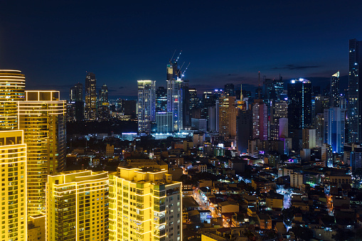 View towards Makati in Metro Manila at night, the downtown financial district in the background and illuminated buildings of the Rockwell Center in the foreground.