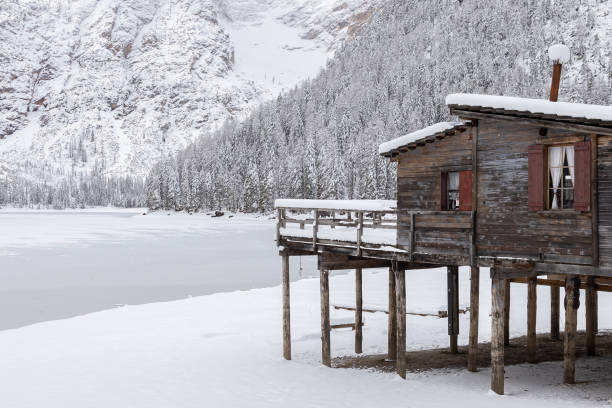 vista de uma cabana de madeira e lago braies completamente gelado em um dia de inverno nevado; dolomitas; alto-adige, itália - altoadige - fotografias e filmes do acervo