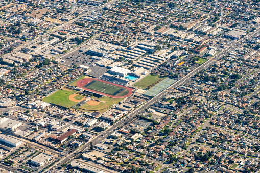 Downey, California, USA - Aerial photograph of Downey California featuring Warren High School, Paramount Boulevard, Football Stadium, Baseball Diamond, Tennis Courts and a Swimming Pool