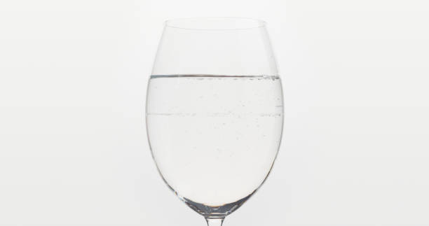 istock poured water into wine glass over white background 1497264696