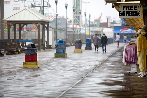 Seaside Heights, New Jersey, USA - May 4, 2023: Daytime view of the mostly empty boardwalk on an overcast rainy day.