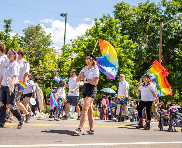 grupo de personas con piloto femenina agitando el desfile del orgullo lgbtqia + marchando bandera gay utah slc salt lake city apoyo caminando juntos - homosexual gay pride business rainbow fotografías e imágenes de stock